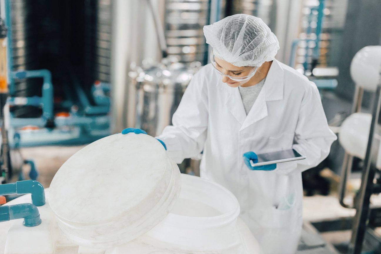 Bild einer Frau in einem Laborkittel, die einen Behälter hält.