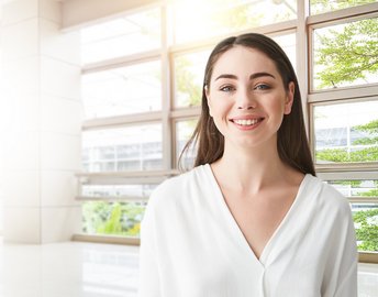Eine lachende Frau vor einem Fenster.