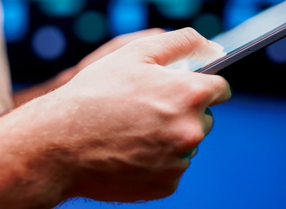 Eine Person hält ein Tablet.