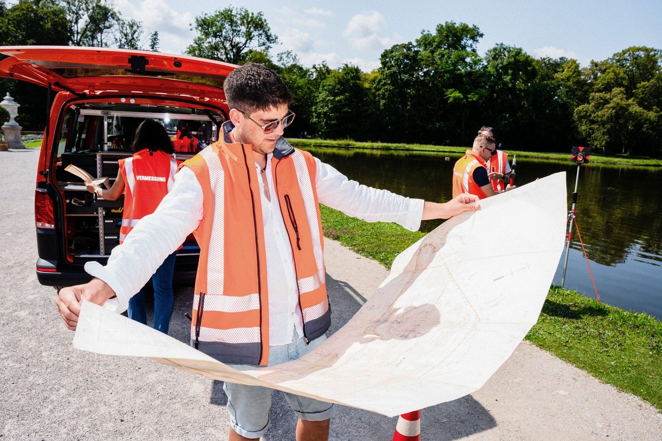 Mann hält große Karte in den Händen und blickt darauf.
