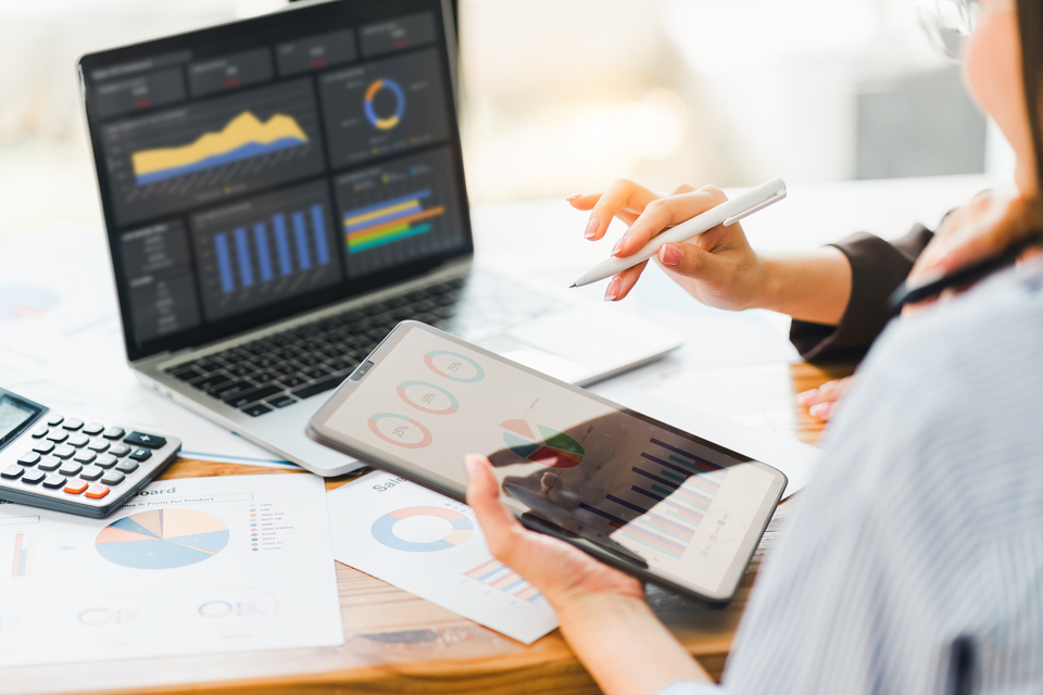 Menschen, die Diagramme auf einem Tablet anschauen.